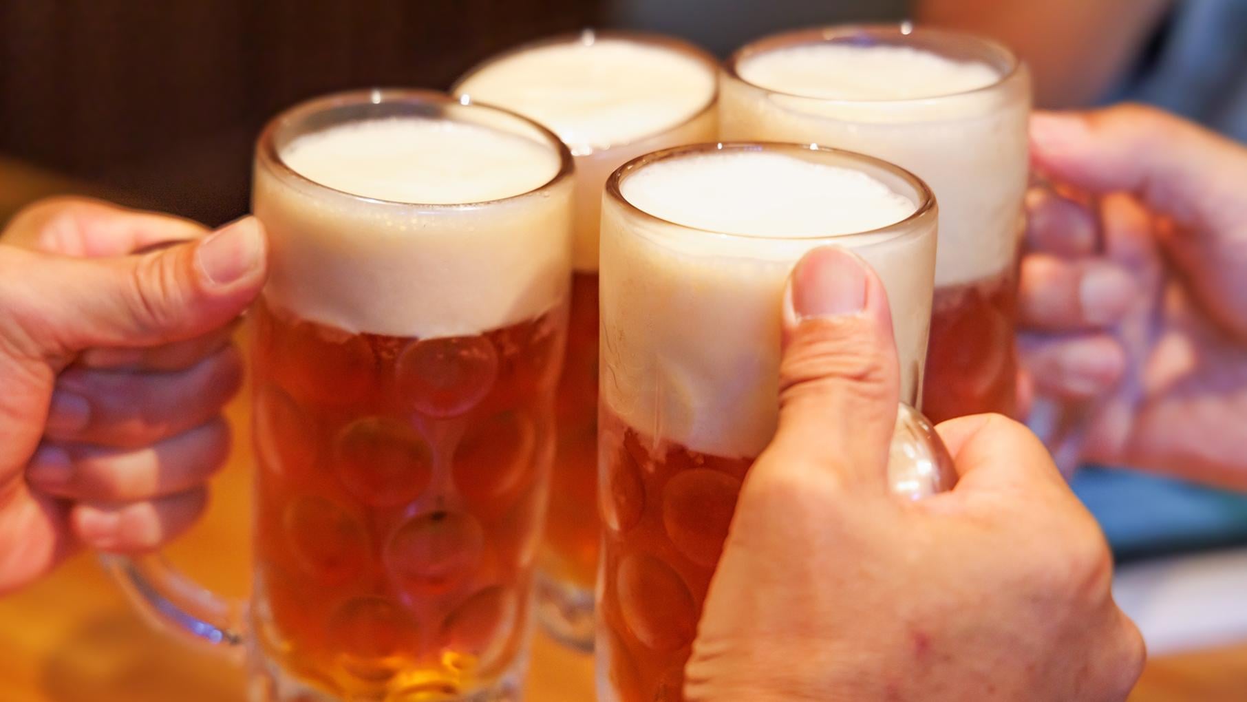 Four beer steins clinking together