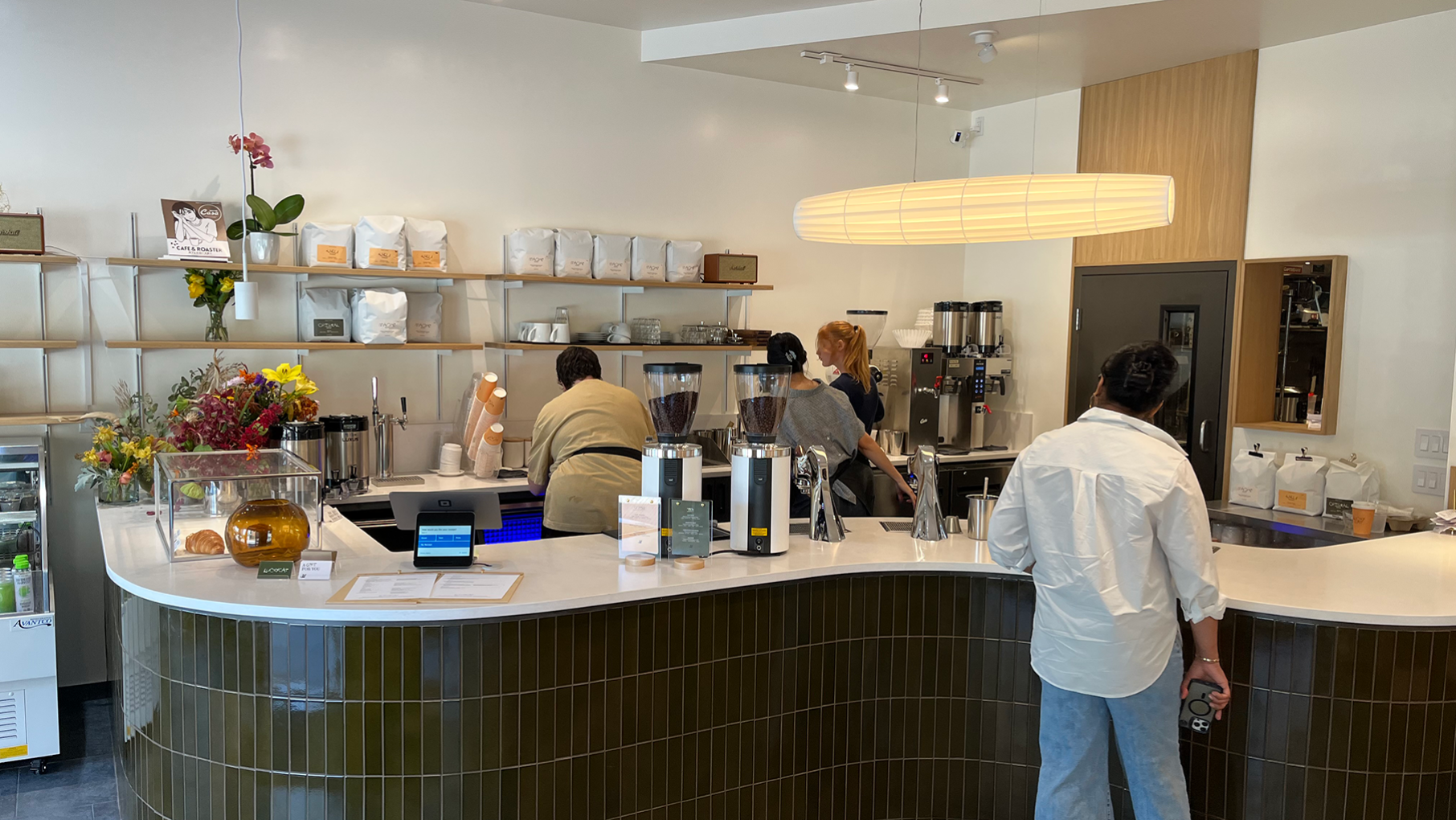 A cafe bar with people working behind it