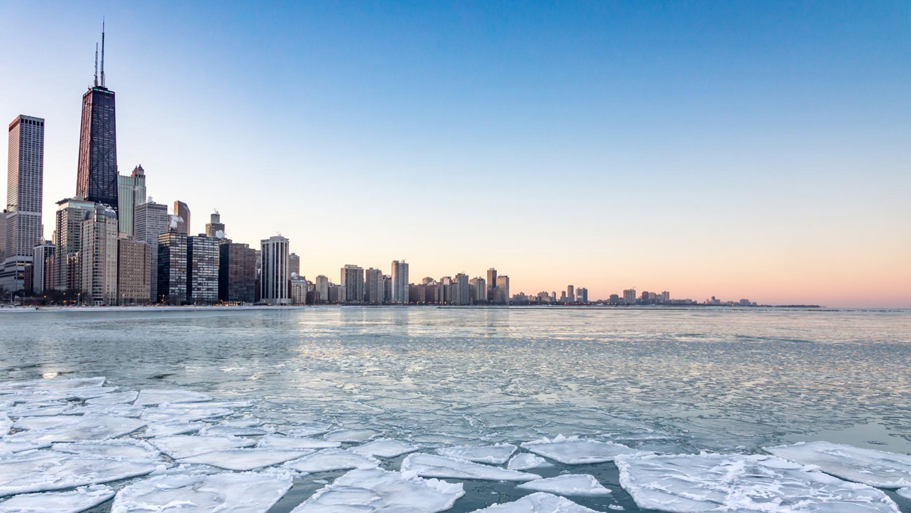 Chicago's skyline is pictured in the background, and a partially frozen Lake Michigan is visible in the foreground.