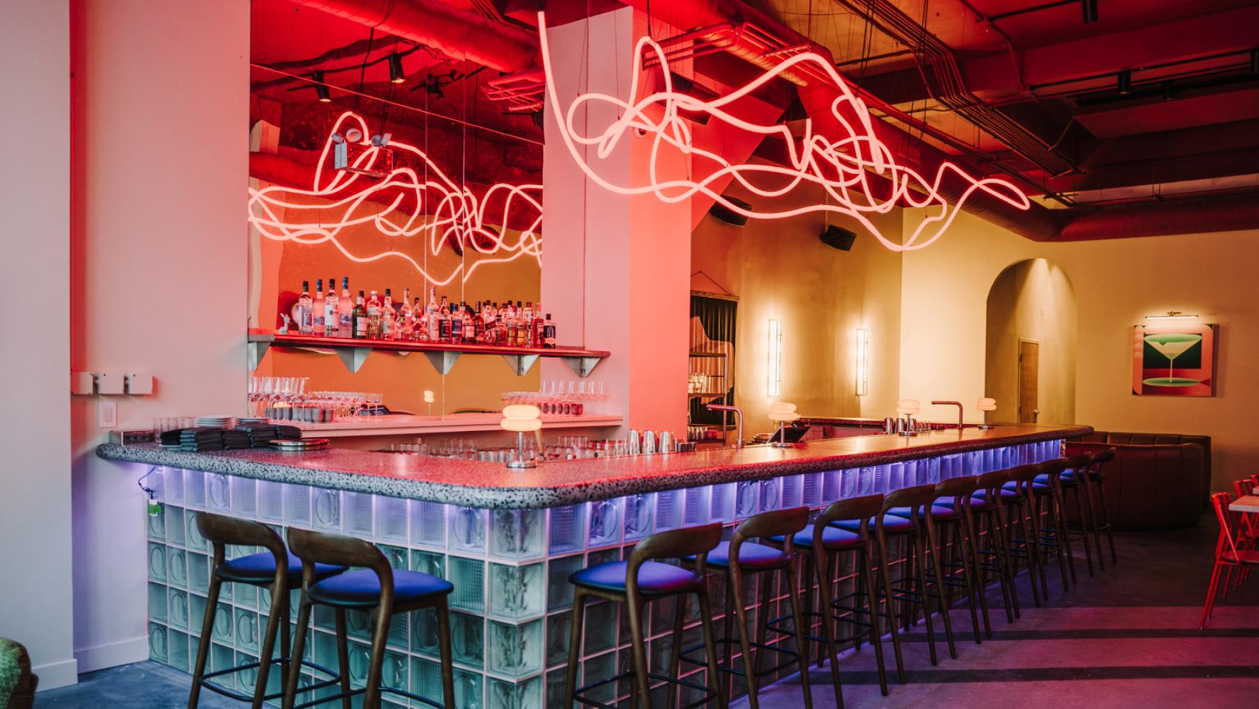 A bar under a pink neon light fixture