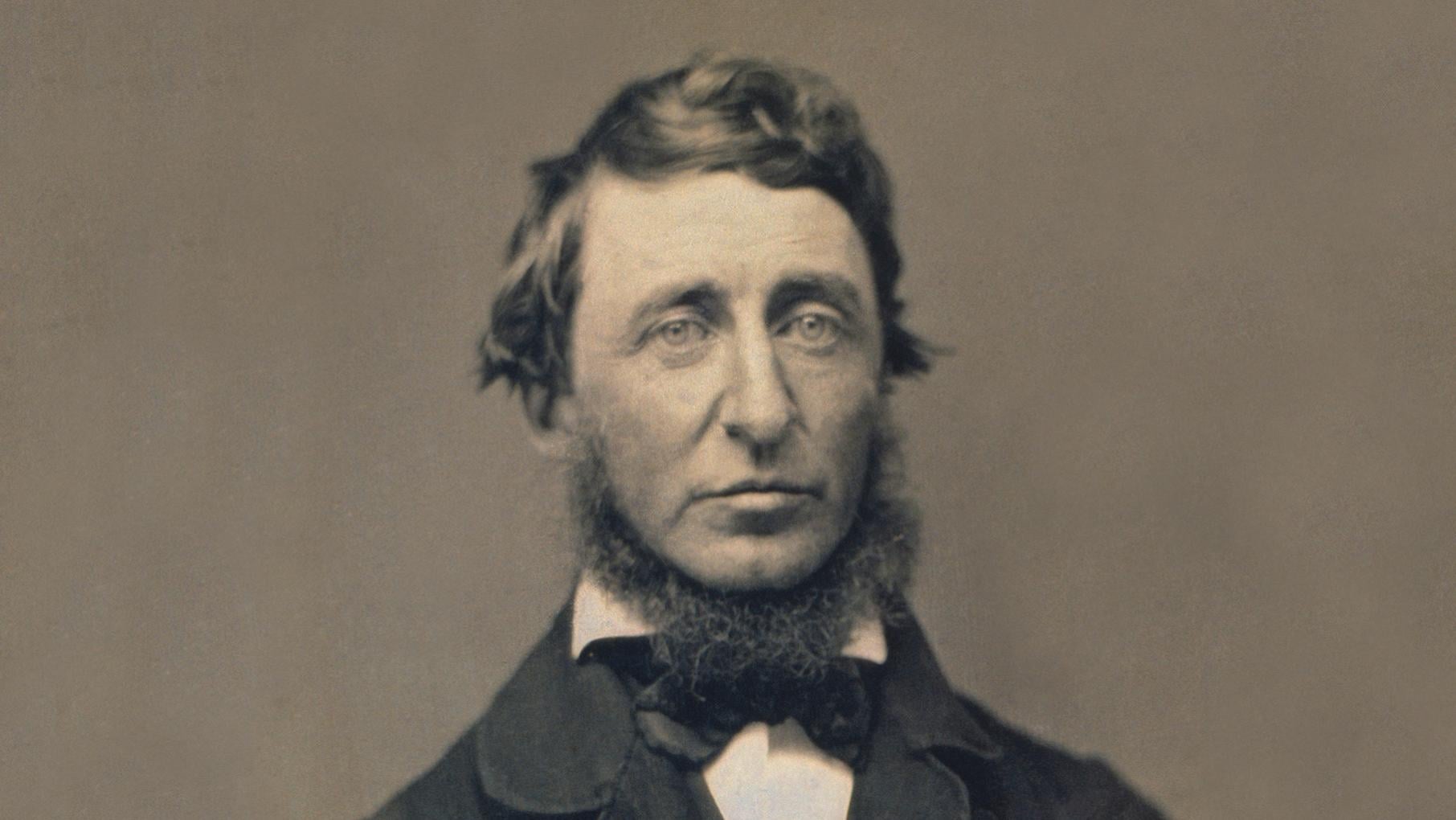 A black and white photo portrait of a bearded Henry David Thoreau in a suit