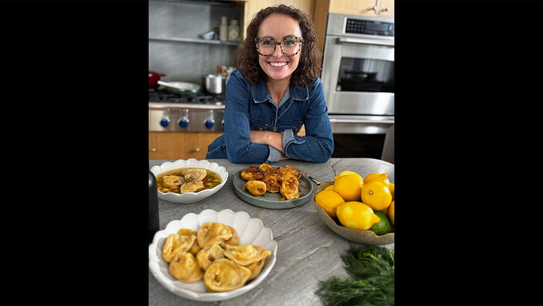 Micah Siva smiles at a counter with three versions of her kreplach