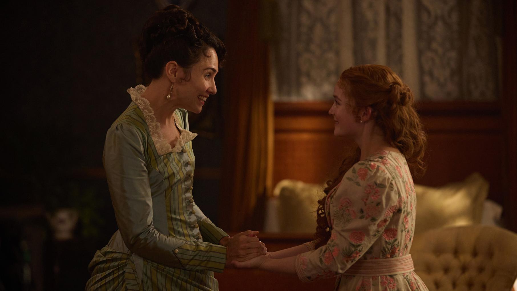 Frances holds Irene's hands as they face each other