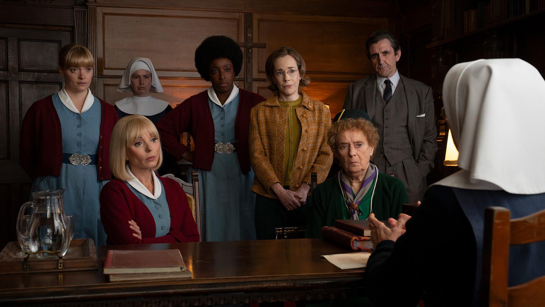 All the midwives and Dr. Turner gather to face Sister Julienne at her desk