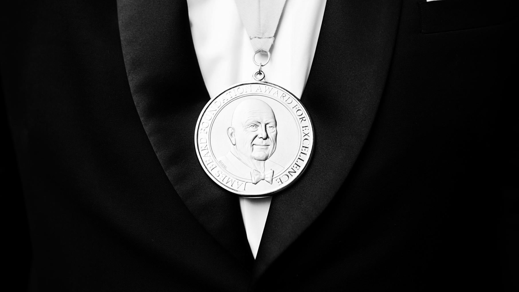 A James Beard Award medal on a tuxedoed chest