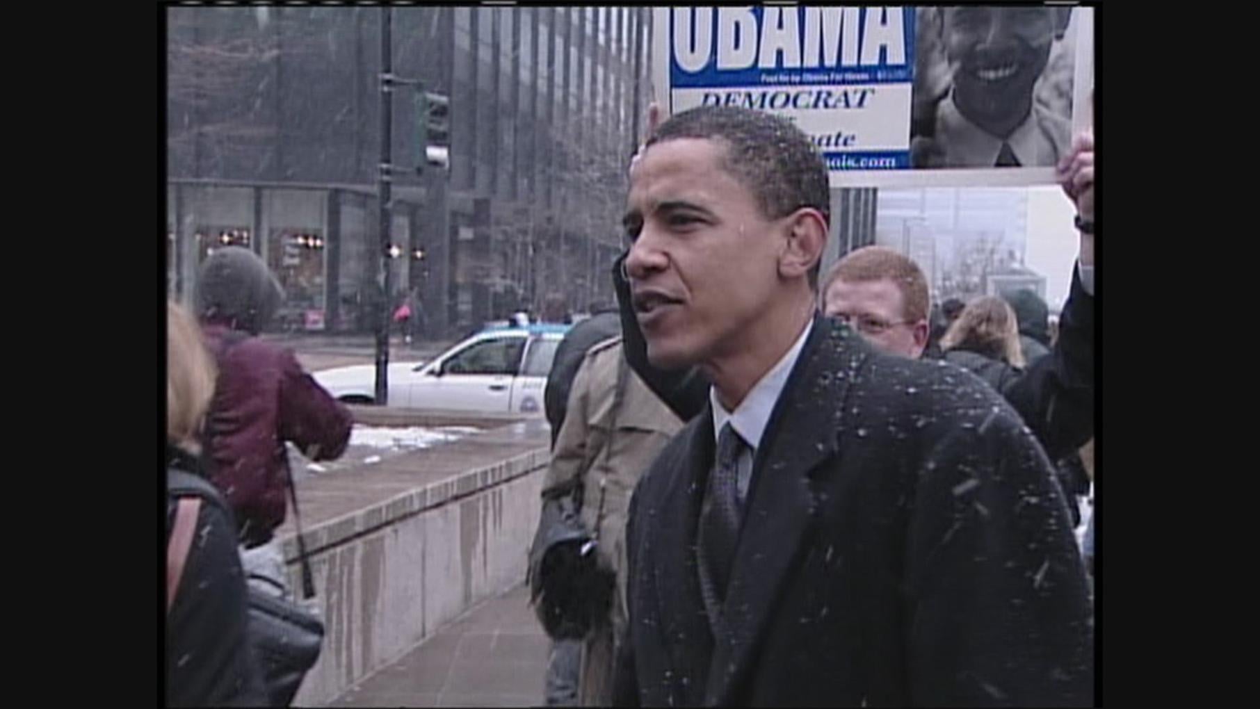 Barack Obama stands on the street in snow as a young man