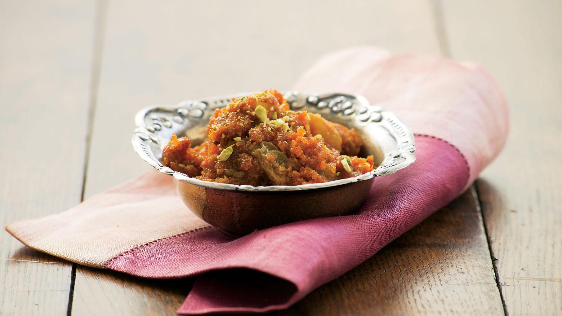 A bowl of gajar ka halwa on a folded napkin on a table