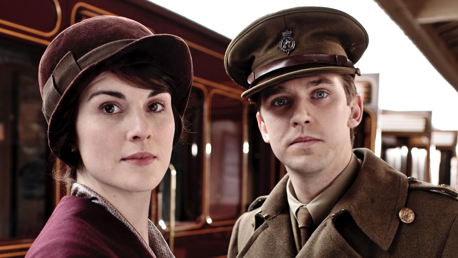 Matthew stands in his military uniform next to Mary at the train station