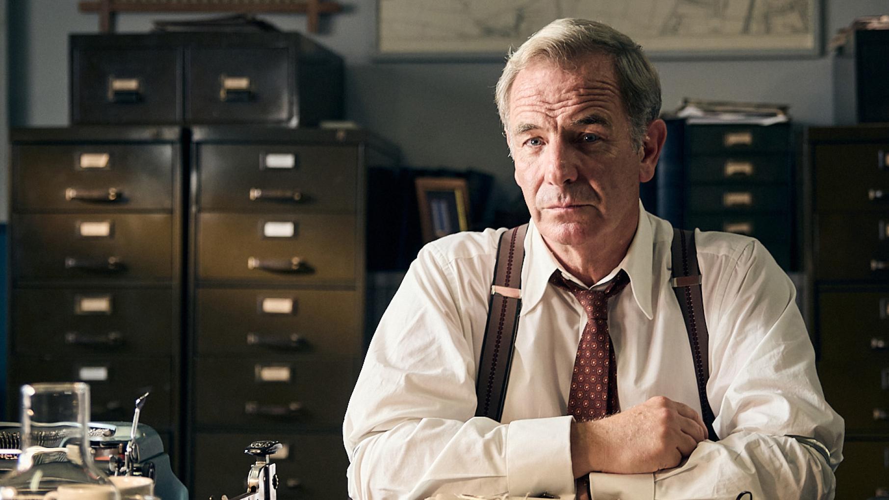 Geordie sits at his desk at the police station