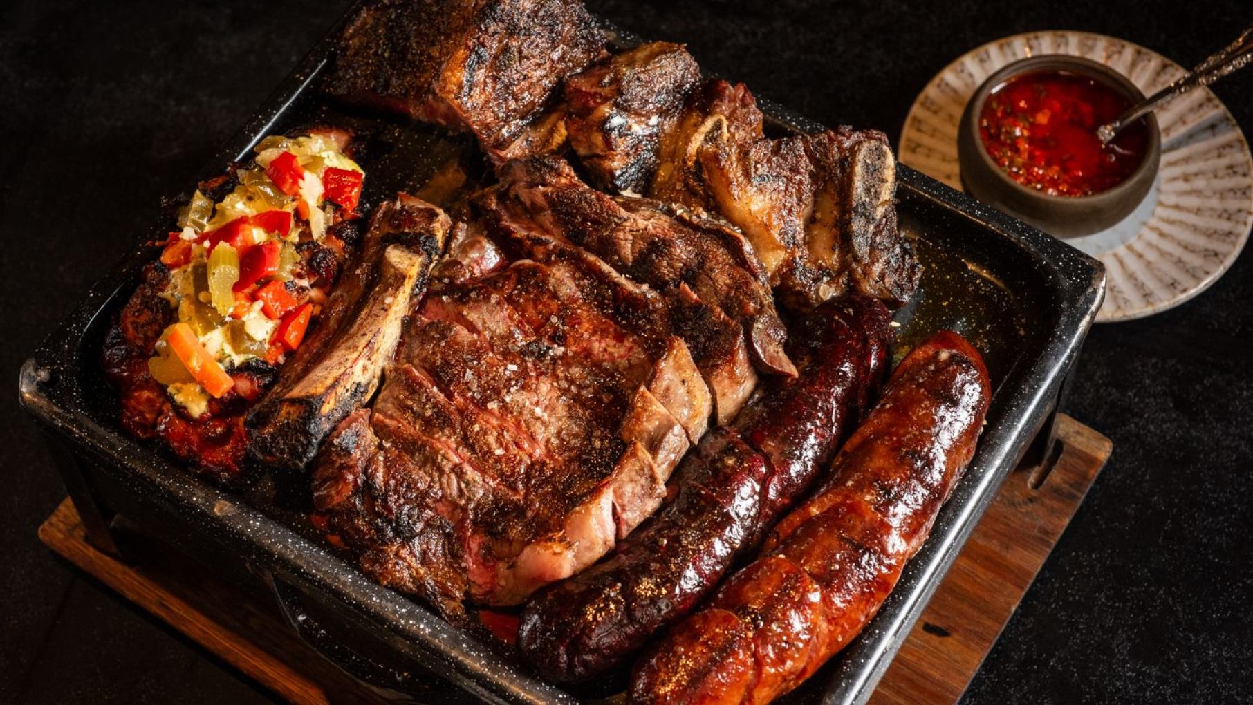 A box of mixed grilled meats on a table