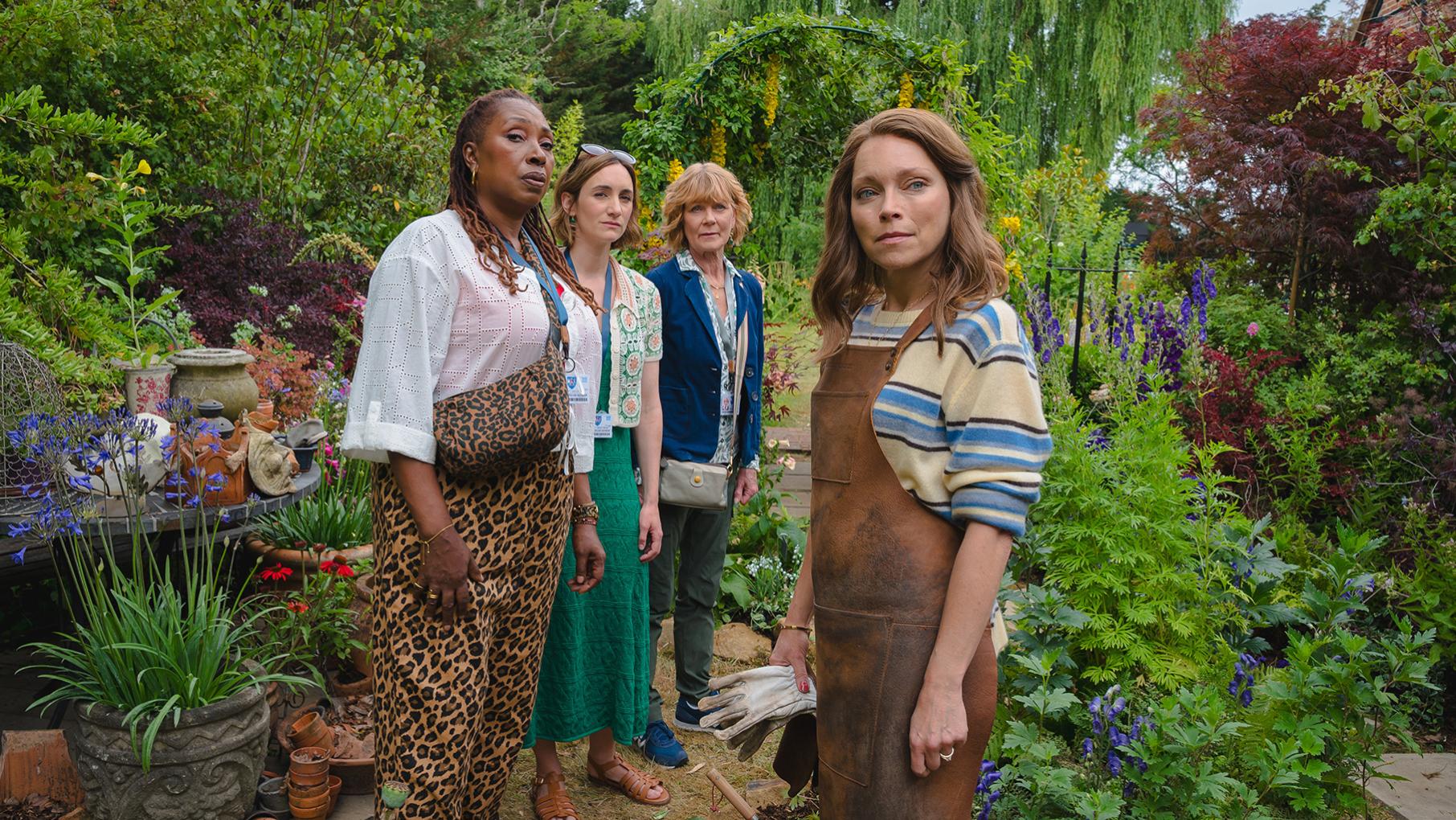 Suzie, Becks, and Judith stand in a garden with Sophia