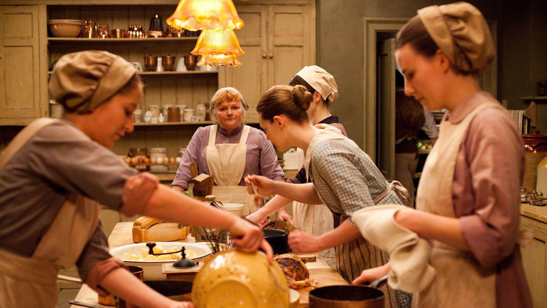 The kitchen staff of Downton Abbey works at a long table