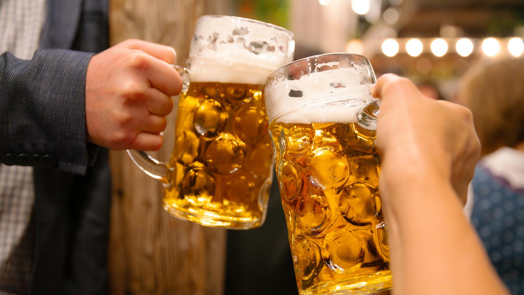 Two beer steins clinking together