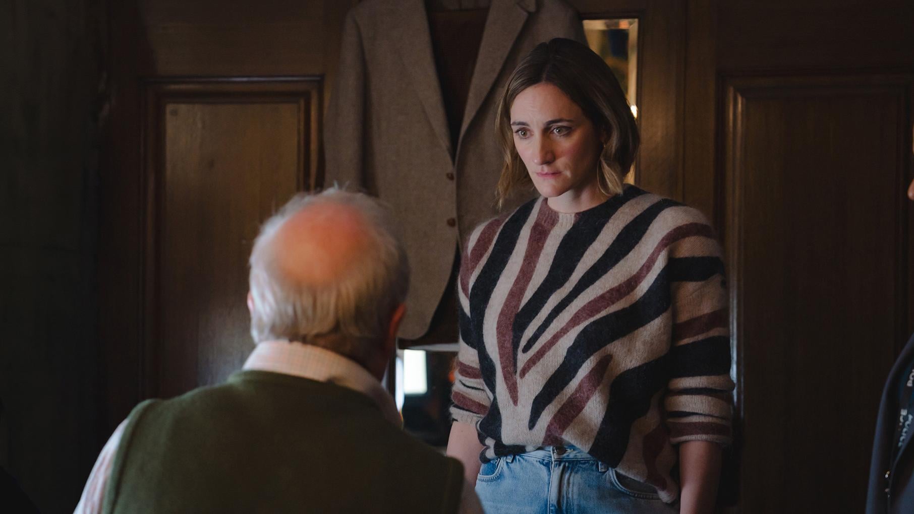 Becks looks down at a man with his back to the camera