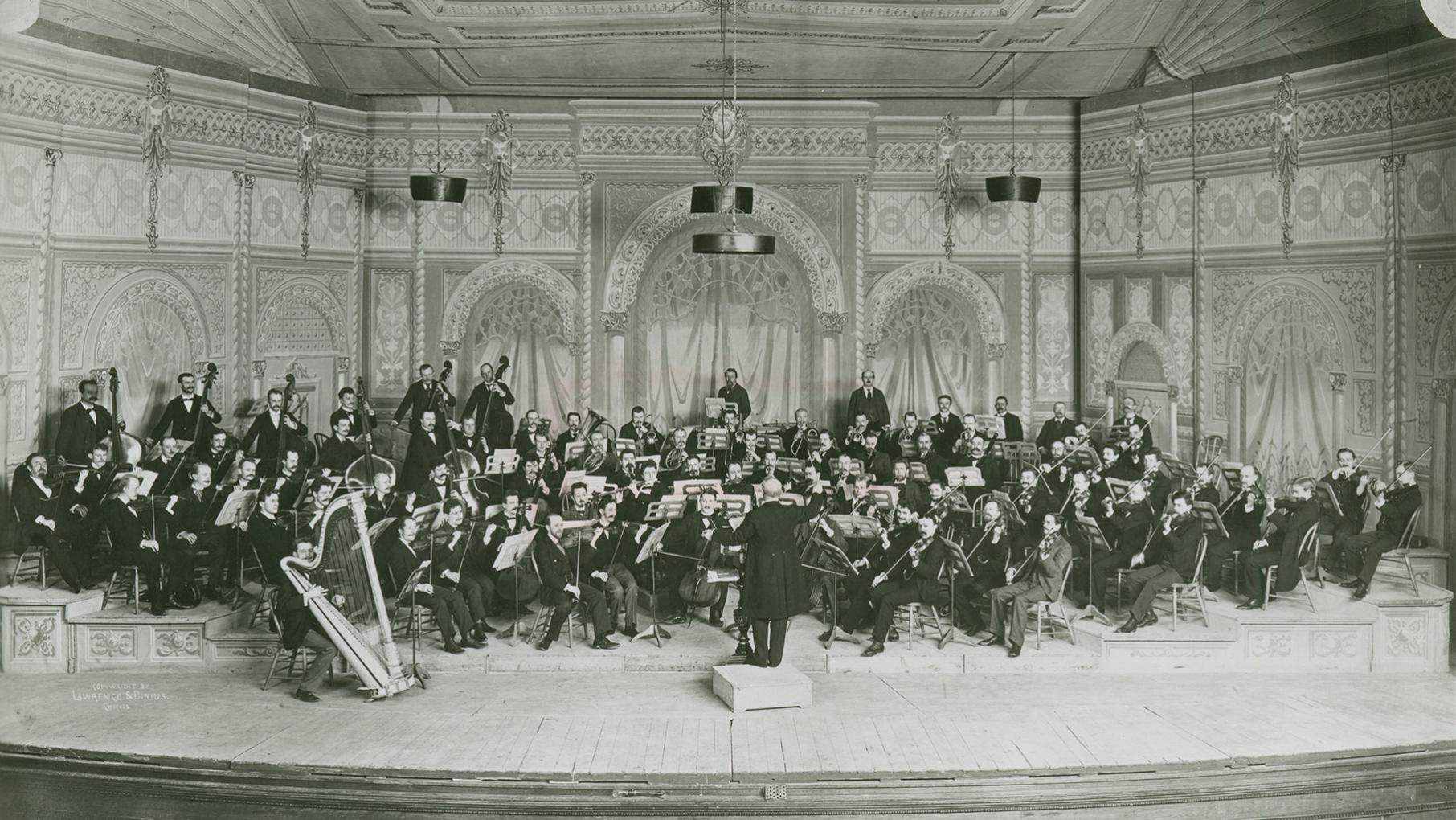 A black and white photo of an orchestra on a stage