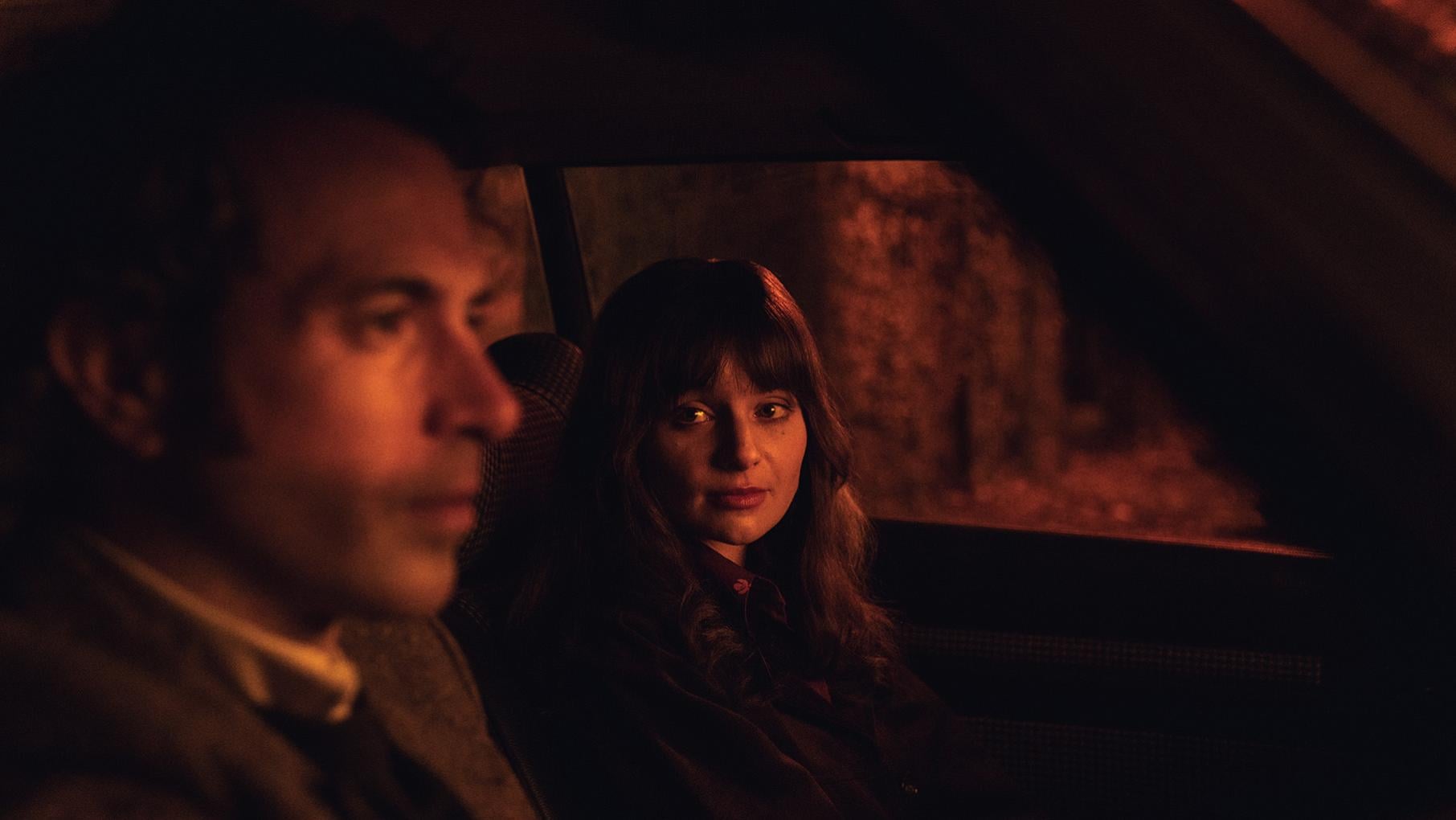 Cushla and Michael sit in a dark car, with her looking at him