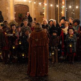 A crowd of carolers outside 