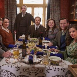 The cast of All Creatures Great and Small smile around a table