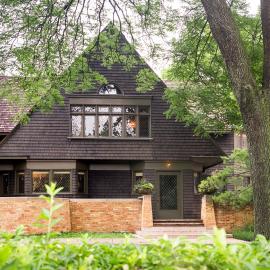 The triangle roof of Frank Lloyd Wright's house, with a tree and greenery in front