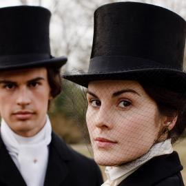 Mary and Kamal Pamuk in top hats outside