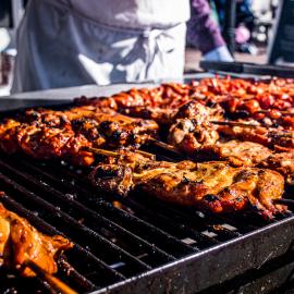 Several kabobs on a large outdoor grill