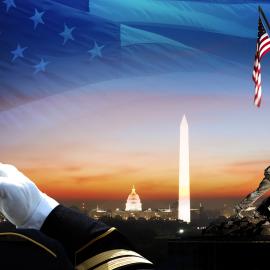 A soldier salutes with monuments in the distance