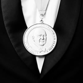 A James Beard Award medal on a tuxedoed chest