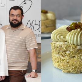 Iryna and Artur Yuzvik pose in their restaurant Abrah, next to a photo of a small pistachio Kyiv cake