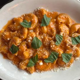 A dish of rigatoni alla vodka topped with basil