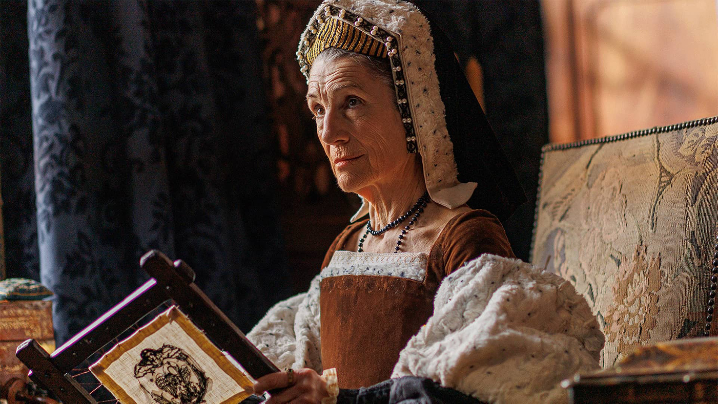 Lady Margaret Pole holds needlework and looks up at someone