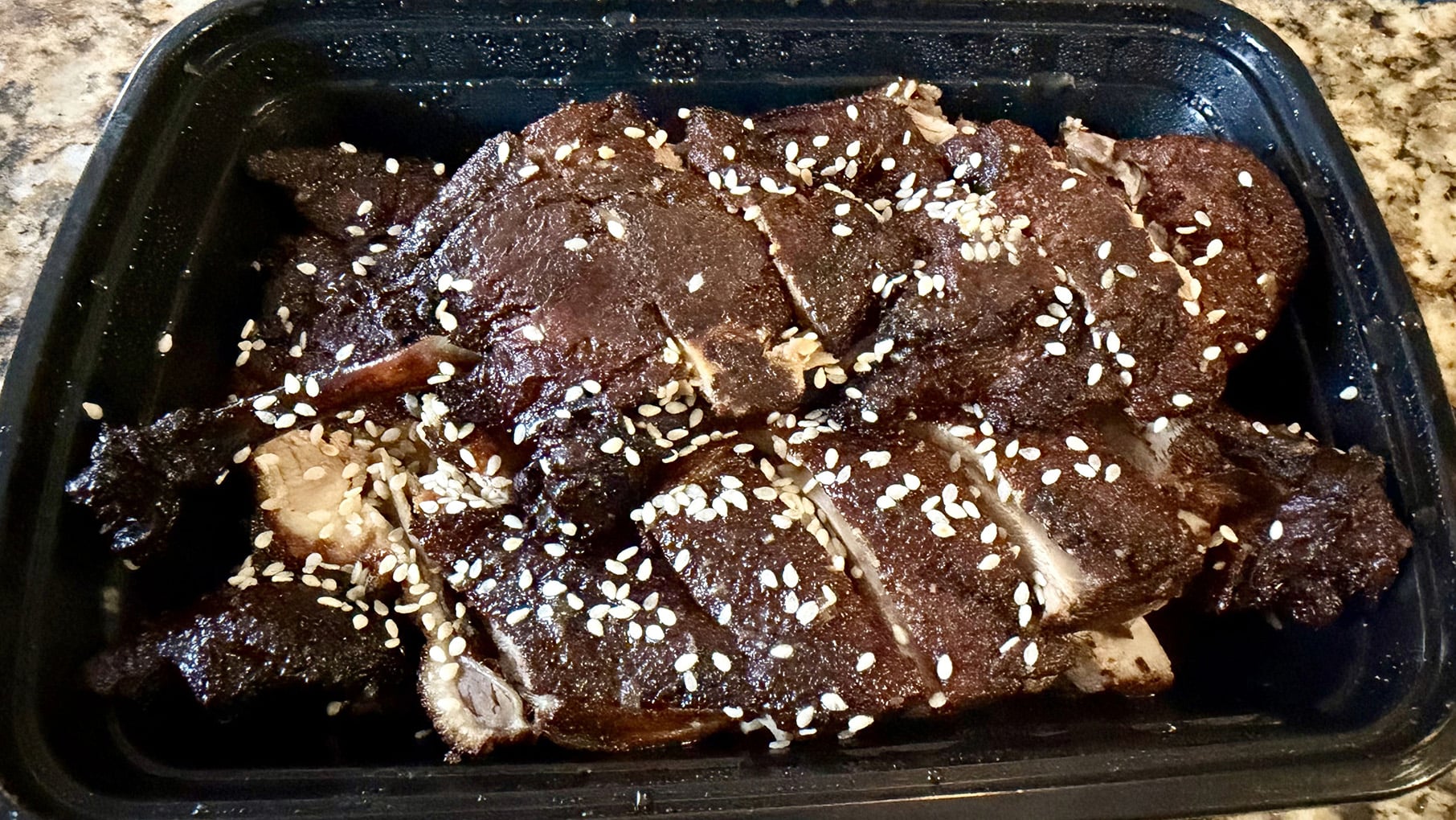Brown-skinned duck in a plastic takeout container